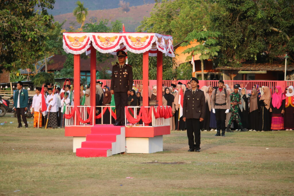 KAPOLSEK MANGGELEWA IPDA YADHULUL MUSLIHIN PIMPIN UPACARA PENURUNAN BENDERA DI LAPANGAN BOLA DESA SORIUTU PADA HUT RI KE-79